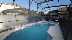 A swimming pool with a hot tub and seating area, surrounded by a covered structure. - Cumbrian Lakes 25 (Kissimmee)
