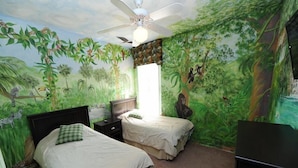 A bedroom with two beds, a ceiling fan, and a mural of a jungle scene. - Cumbrian-lakes-38 (Kissimmee)
