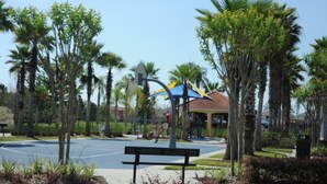Ein Park mit Basketballplatz, Spielplatz und Laube.