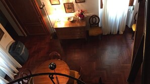 Un coin repas avec une table et des chaises en bois, une lampe et des tableaux encadrés accrochés au mur.