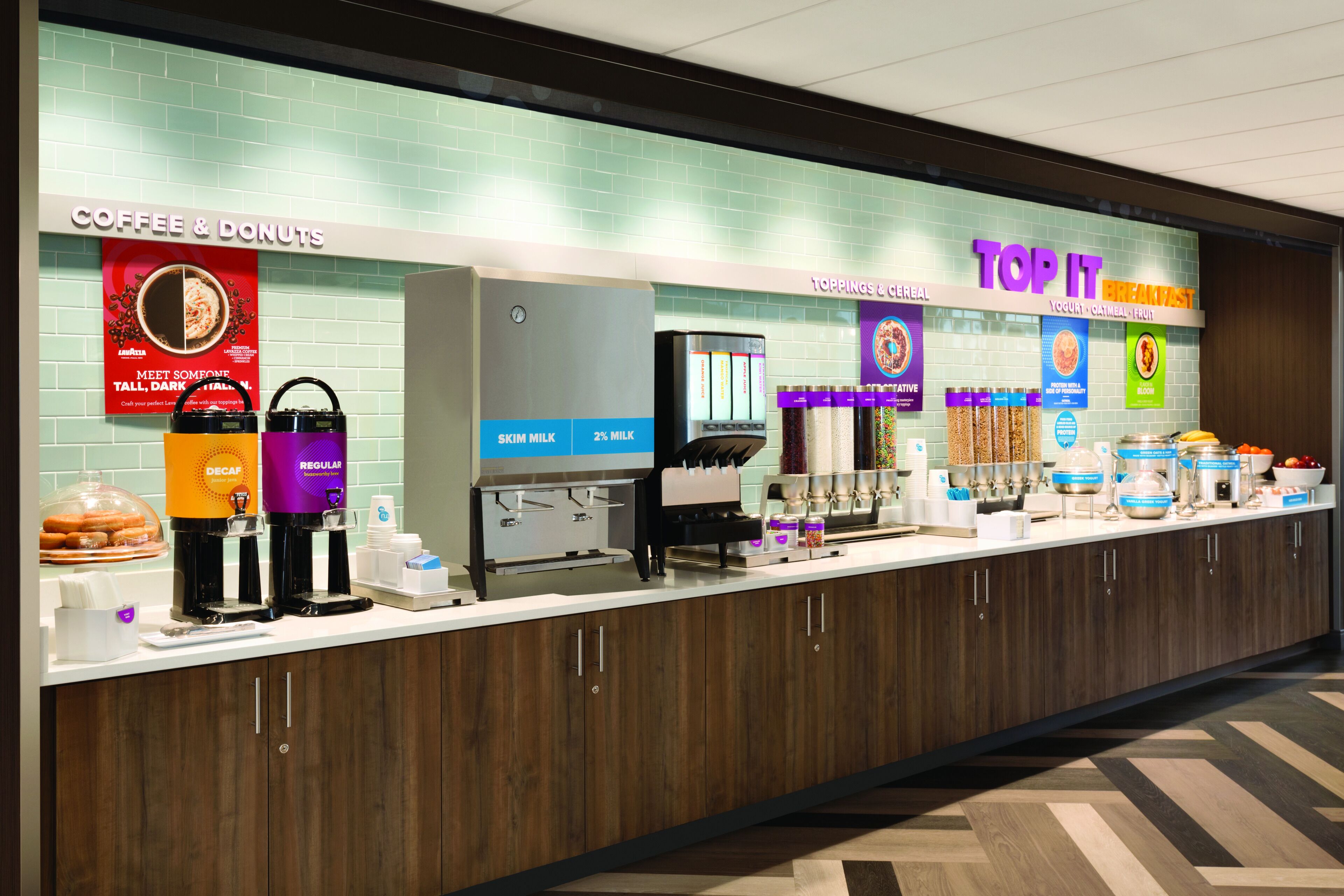 Kaffee- und Donuts-Station mit entkoffeiniertem und normalem Kaffee, eine Müslibar mit Joghurt und ein Frühstücksbereich zum Selbstgestalten.