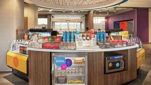 A self-service beverage station with a variety of drinks and snacks, a microwave, and a refrigerated section.