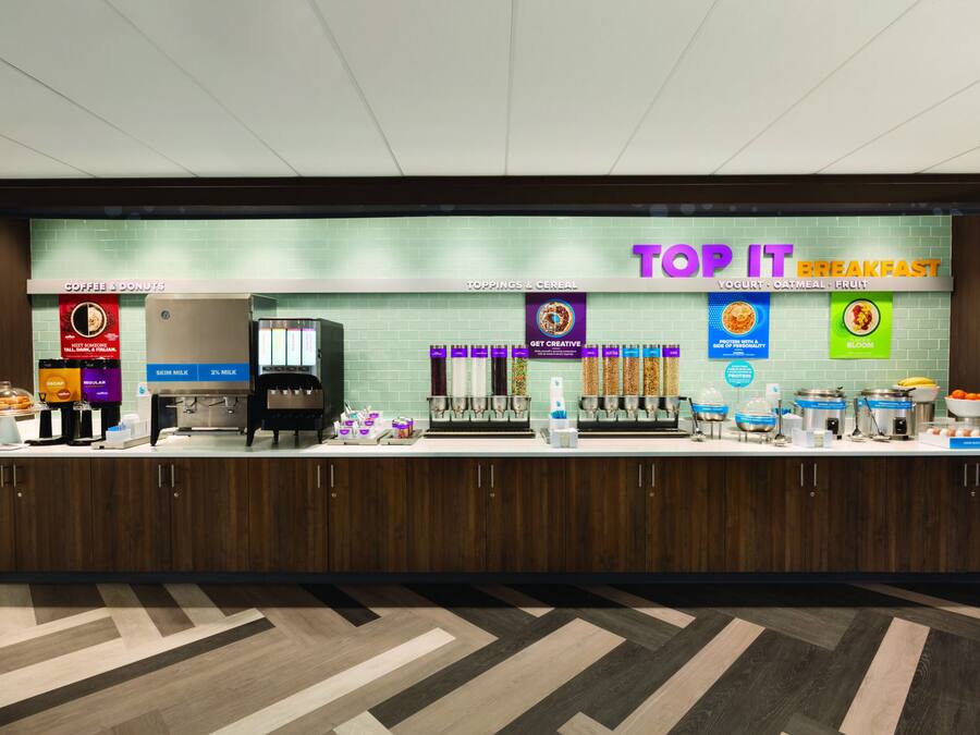 A breakfast counter with coffee, donuts, and cereal options.