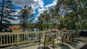 A wooden deck with outdoor seating and potted plants. - 🐾23 Dolman - Amalaran - 360' of frontage on Dodge Pond, dog friendly (Rangeley)