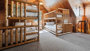 Een chalet met een schuin dak en houten stapelbedden.
