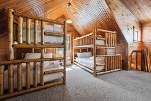 Eine Holzhütte mit geneigtem Dach und Etagenbetten.