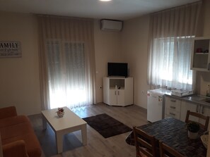 Apartamento família, no piso térreo (1) | Sala de estar | TV LCD