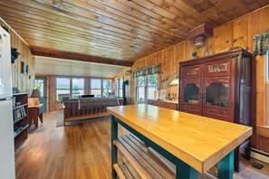 A wooden interior with a wooden table, bench, and cabinets.