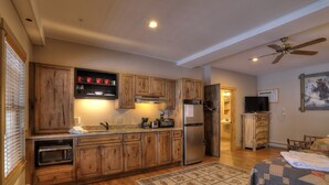 A modern kitchen with wooden cabinets, a stainless steel refrigerator, and a built-in oven. - Oquossoc Suite #5 | A/C (Oquossoc)