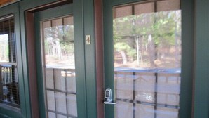 A door with a number 4 sign, a keypad lock, and a view of the outside. - Oquossoc Suite #5 | A/C (Oquossoc)