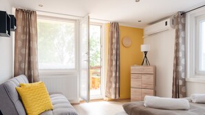 A bedroom with two beds, a dresser, a lamp, and a view of the outdoors. - Casa Montana II- Country Apartment (Balatonalmadi)
