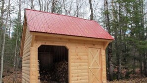 Un petit abri en bois avec un toit rouge, une porte et une entrée ouverte.