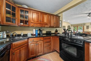 A kitchen with wooden cabinets, a stove, and a sink.