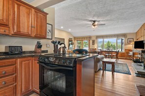 Un'ampia cucina con mobili in legno, un piano cottura e un'area pranzo con vista.