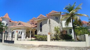 Una casa grande de varios pisos con fachada de piedra, varios balcones y entrada con portón.
