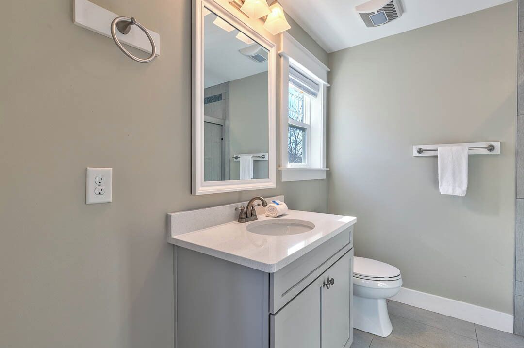 A bathroom with a sink, mirror, and toilet.