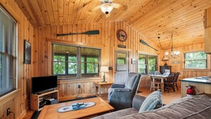 Ein Holzblockhaus mit Wohnbereich, Essbereich und Küche.