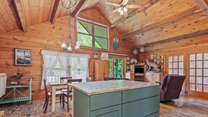 L’intérieur d’un chalet rustique comprend un îlot de cuisine, une table à manger et des chaises.