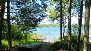 A natural setting with a wooden dock extending into a lake, surrounded by trees and vegetation. - 27 Depot - Adorable 2 bedroom, 2 bath cottage close to the village (Rangeley)
