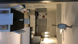 A modern kitchen with white cabinets, a stainless steel refrigerator, and a built-in oven. - Cozy Scandinavian Bungalow near KLIA & Sepang F1 (KOTA SERIEMAS)