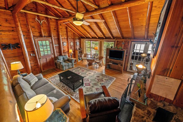 A cozy log cabin interior with a living room, fireplace, and wooden walls. - 🐾Kadel - Maine log home on Mooselookmeguntic Lake filled with rustic charm, dog friendly (Oquossoc)