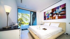 Ein modernes Schlafzimmer mit Bett, Schreibtisch und großem Fenster.