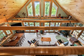 Un vaste espace de vie de style loft, doté d’un haut plafond, de grandes fenêtres, d’une cheminée et d’un coin salon confortable.