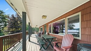 Une terrasse en bois avec des tables et des chaises pour pique-niquer, offrant une vue panoramique.