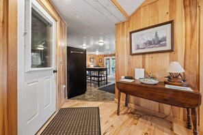 A wooden interior with a dining area, a black refrigerator, and a framed picture on the wall. - Pine Valley - Great newly renovated cabin - close to the village of Oquossoc (Rangeley)