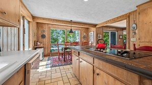 A kitchen with wooden cabinets, a large island, and a view of the outdoors.