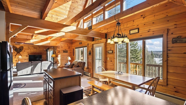A cabin interior with a kitchen, dining area, and living room.