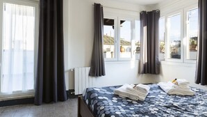 Une chambre d’hôtel avec un lit, des rideaux, un radiateur et des fenêtres.