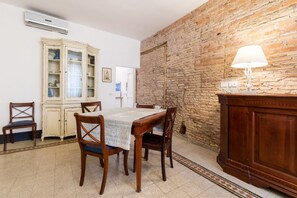 Een eethoek met een tafel, stoelen, een kast en een lamp.