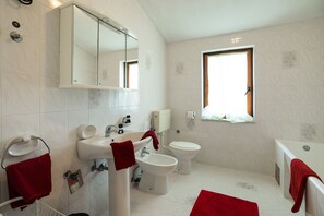 Un bagno moderno con lavabo, bidet, water e vasca da bagno.