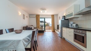 Una cocina moderna con comedor, que incluye una mesa con sillas, un refrigerador y una cafetera.