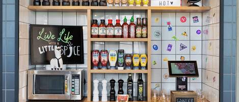 Una encimera de cocina con diversos condimentos, un microondas, un dispensador de agua y un letrero que dice 'Live Life with a Little Spice'.
