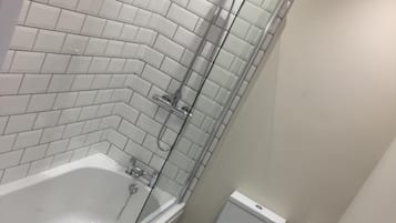 A modern bathroom with a freestanding bathtub, a toilet, and a sink.