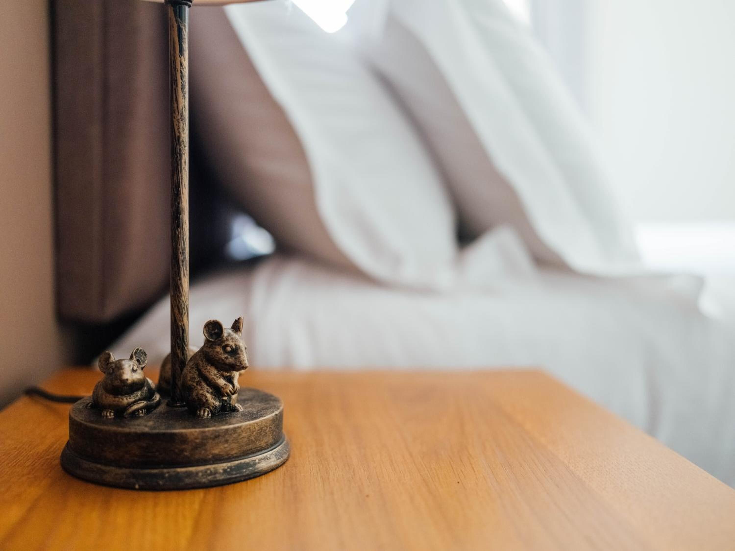 Une table en bois avec une lampe et deux petites figurines.
