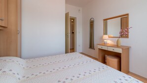 A bedroom with a bed, a dresser, a mirror, and a nightstand. - Mandic Apartment - Seaside Views, Beach Nearby (Mastrinka)