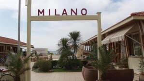 Un letrero con la palabra 'MILANO' sobre la entrada de un edificio.