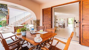 Un comedor con una mesa de madera, sillas y una escalera que sube a un nivel superior.