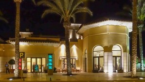 A hotel entrance with palm trees, a parking sign, and illuminated signage. - Stunning Villa - Open Plan & Heated 8m Pool  (Torre-Pacheco)