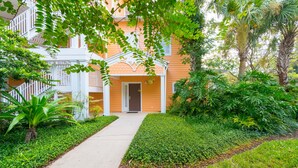 A building with a central entrance, surrounded by lush greenery and a pathway leading to the entrance. - Bahama Bay, Florida 2 Br large condominium (Davenport)