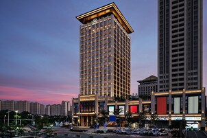 Un hotel moderno de gran altura, con un diseño llamativo, una entrada destacada y varios pisos.