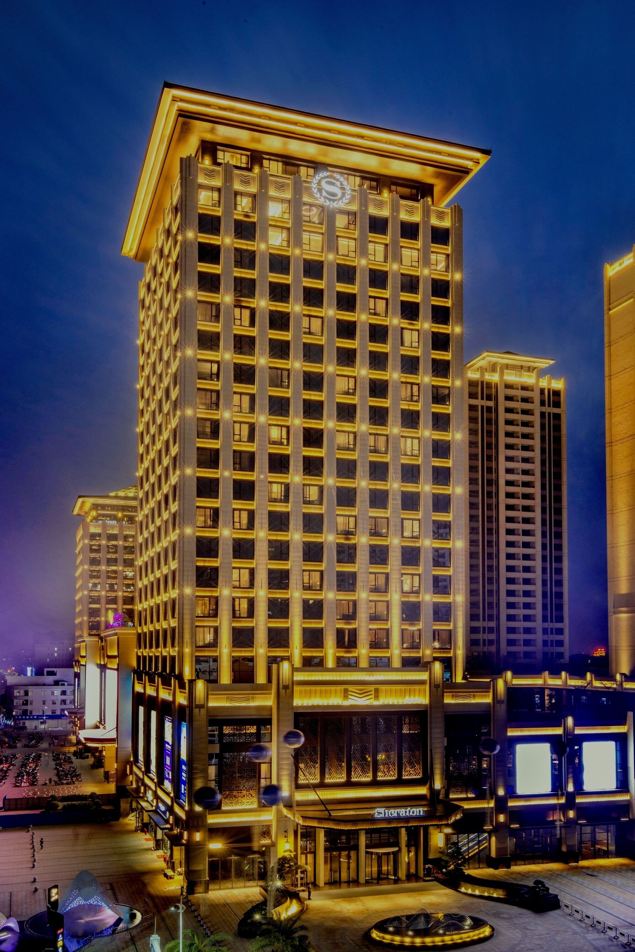 A high-rise hotel with multiple floors, a prominent entrance, and a well-lit facade.