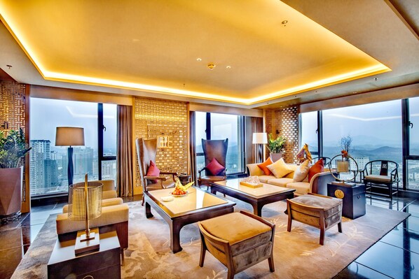 A modern hotel room with a large window offering a city view, a cozy seating area with a sofa and chairs, and a dining table with a lamp. - Sheraton Yunfu Xinxing Hotel (Yunfu)