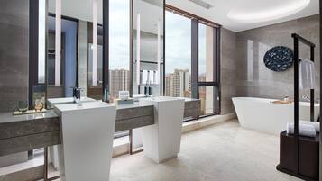 Een moderne badkamer met twee wastafels, een badkuip en een grote spiegel die op de skyline reflecteert.