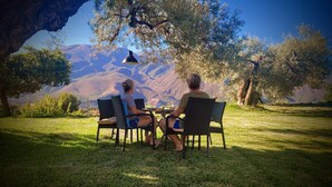 Two people seated at a table outdoors with a mountain view.