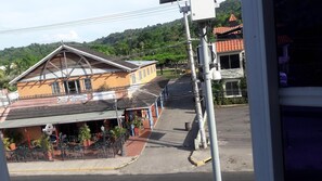 A two-story building with a sign for 'Juan Enterprise' and a restaurant with outdoor seating.