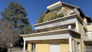 Un immeuble à plusieurs étages, doté de balcons, d’une entrée couverte et d’un toit plat.